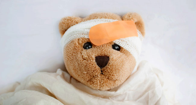 Teddybär mit Pflaster am Kopf